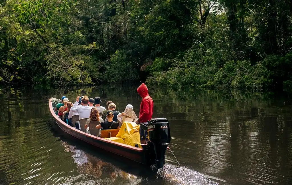Canoa a motor con turistas sobre el río Cuyabeno