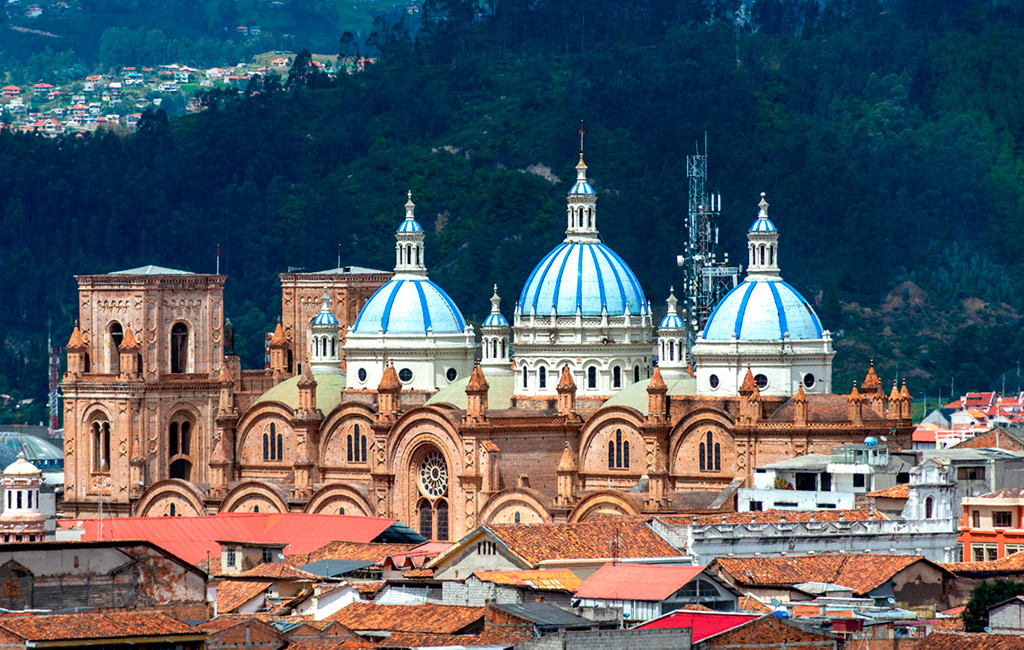 Una catedral de cuenca con cúpulas azules en medio de una ciudad.